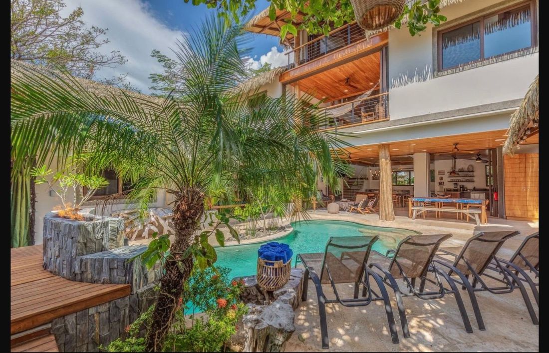 The saltwater lagoon pool, loungers and palms below the villa&rsquo;s open terraces