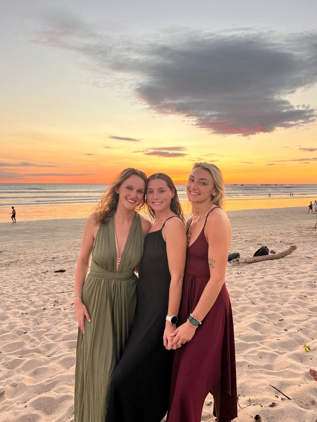 Three women on the sand at Playa Guiones in the late afternoon light